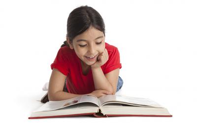 Girl lying down reading a book