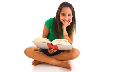 Teenager holding a book and smiling