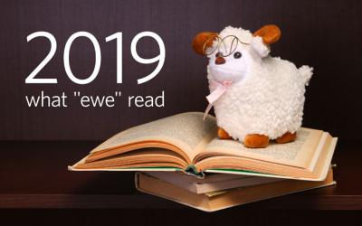 Stuffed sheep toy atop a stack of books