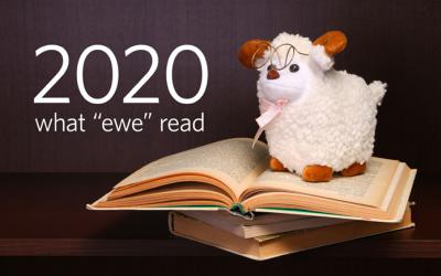Stuffed sheep toy atop a stack of books