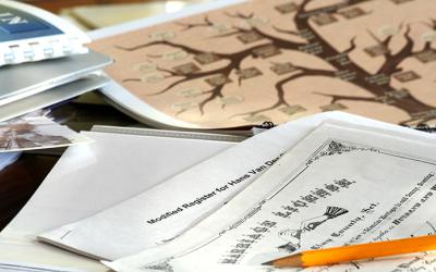 Pencil laying on top of papers, certificates and a family tree