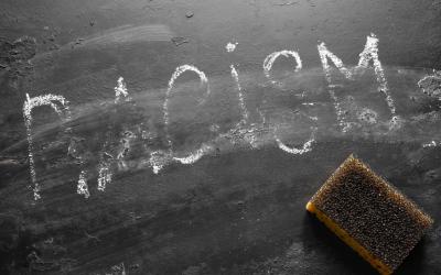 Racism written in chalk on chalkboard partially erased